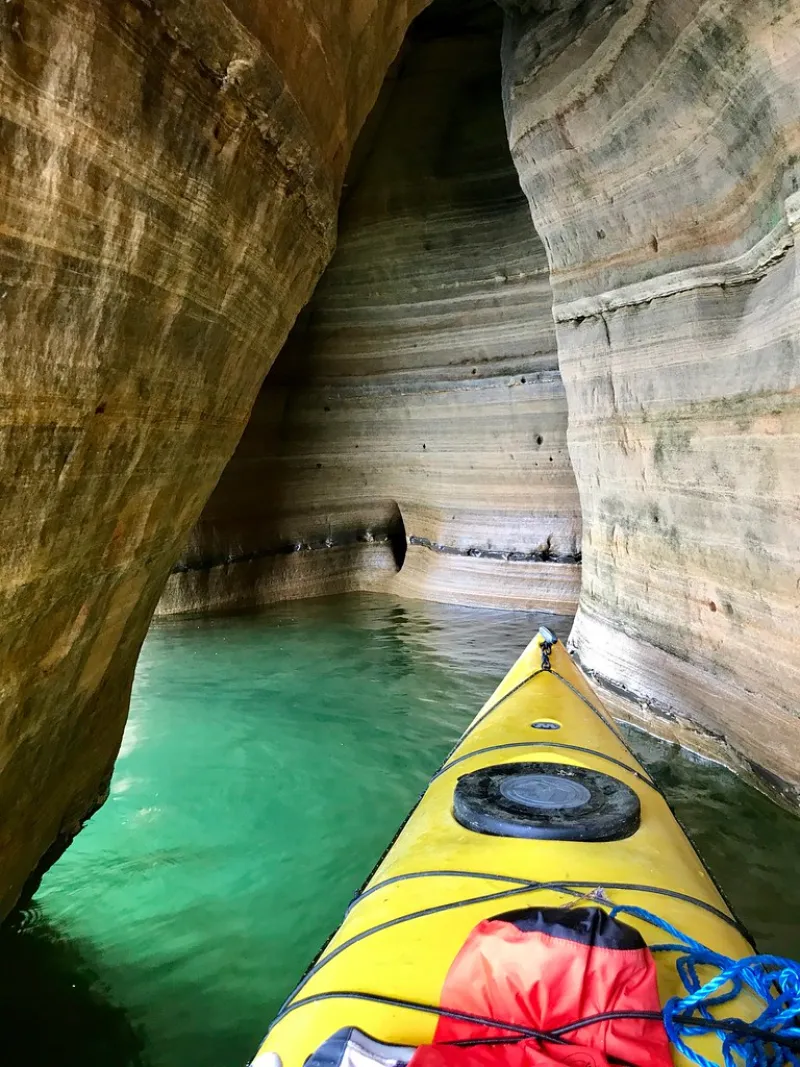 A sea kayak gliding past limestone cliffs on turquoise water
