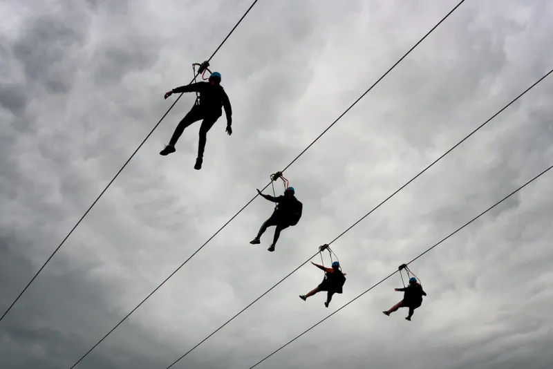 Riders soaring along a zipline cable