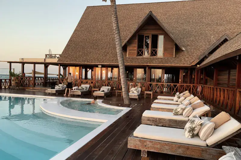 A welcoming hotel exterior with a pool at dusk